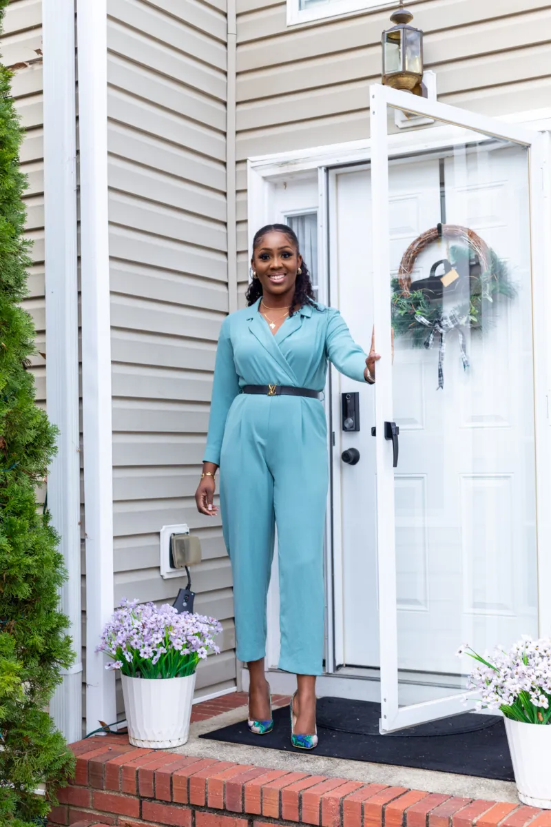 Ama holding open the front door of an Atlanta home