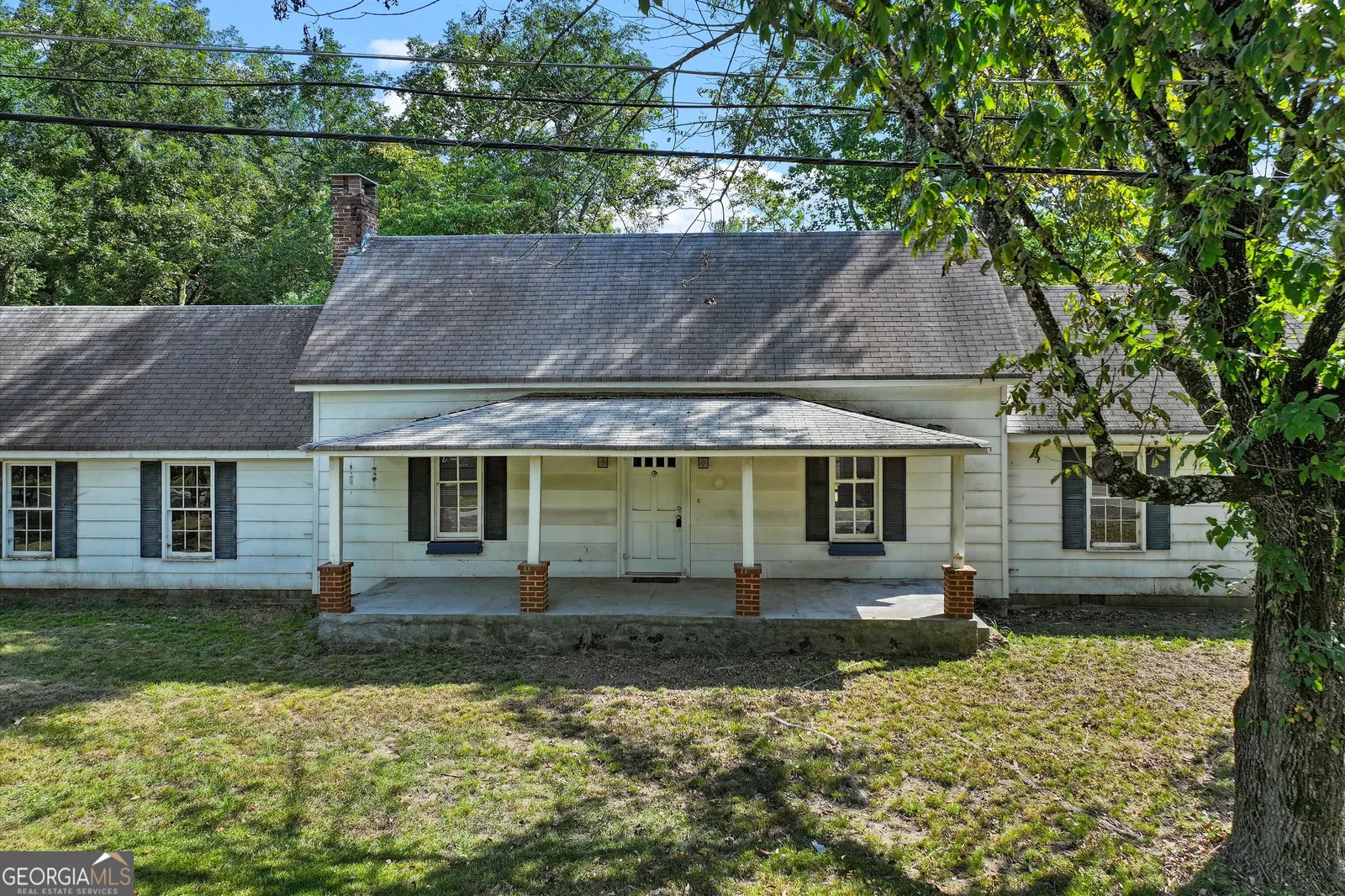 Front of the white clapboard ranch house at 2094 Klondike Rd SW, with a covered porch and a mature oak in the yard