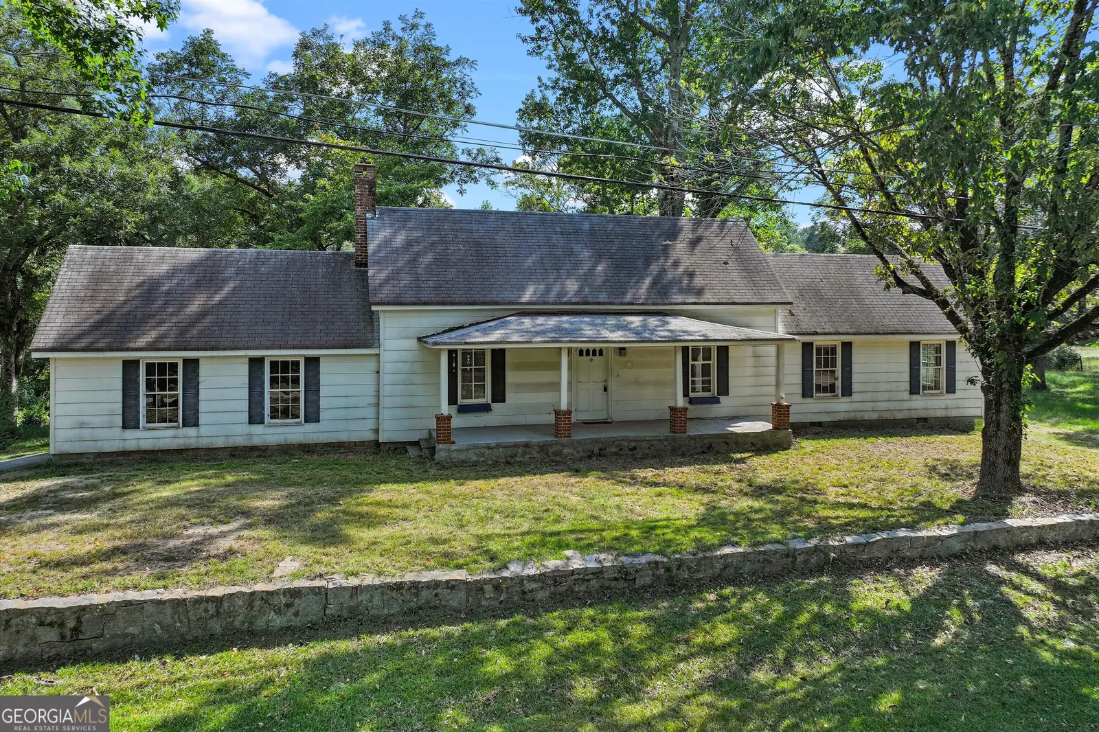 The house seen from the right, showing a second covered porch entry and black window shutters