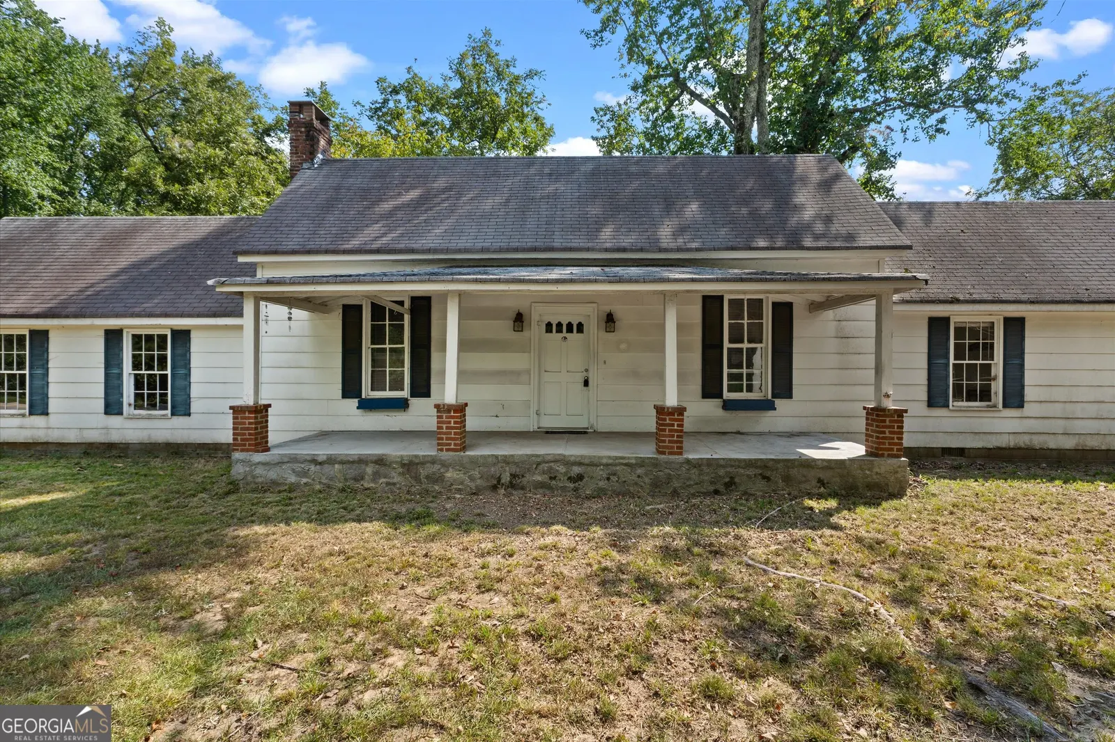 The full front elevation of the house, with a covered porch running its width