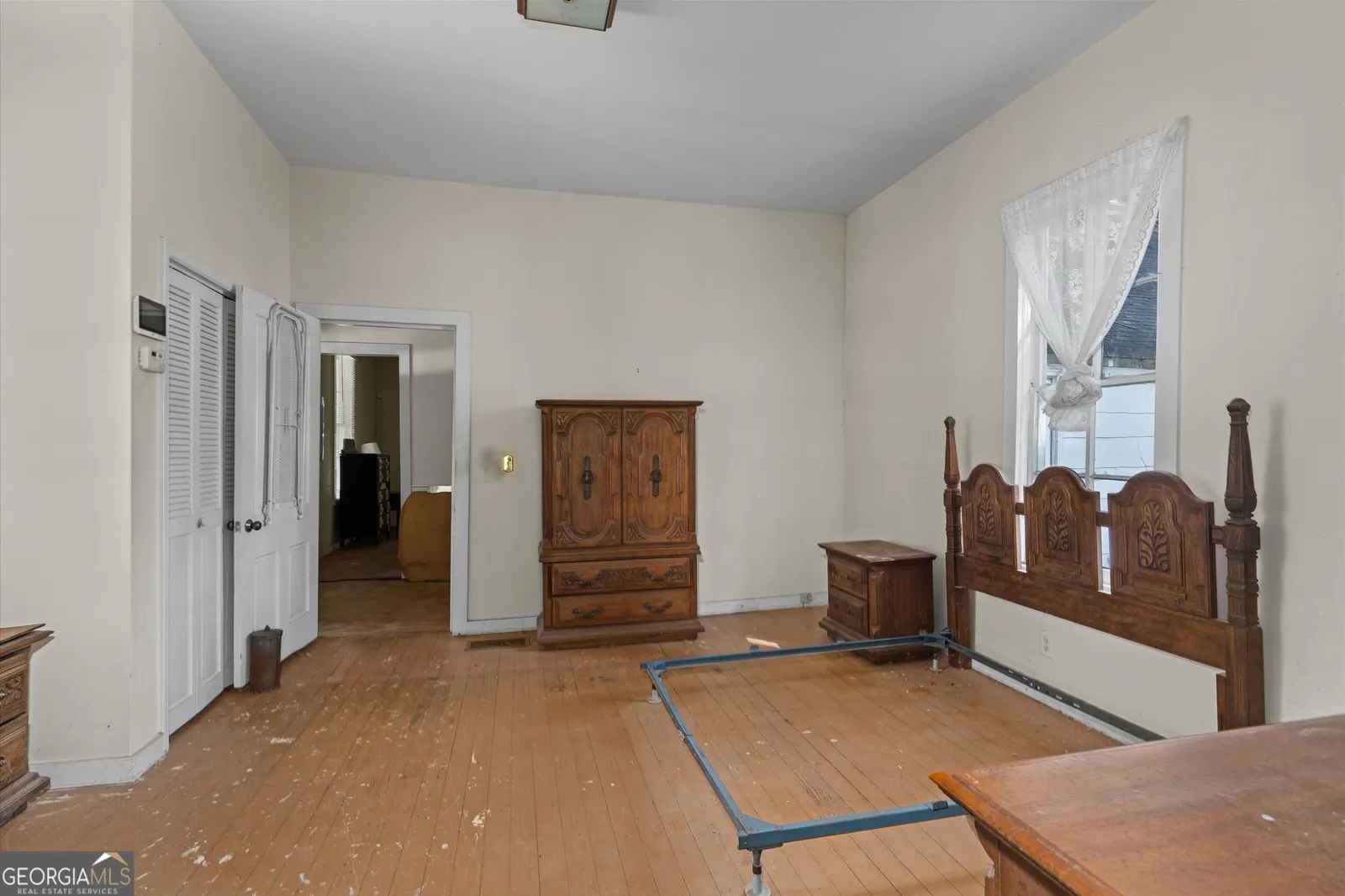 Second bedroom with hardwood floor, a wooden wardrobe and a doorway through to the hall