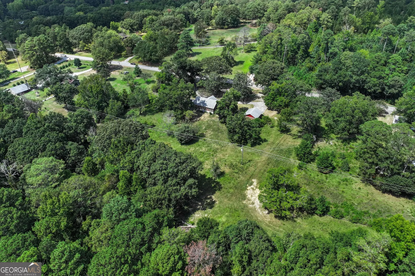 Aerial over the wider neighbourhood, with the property's clearing at the centre