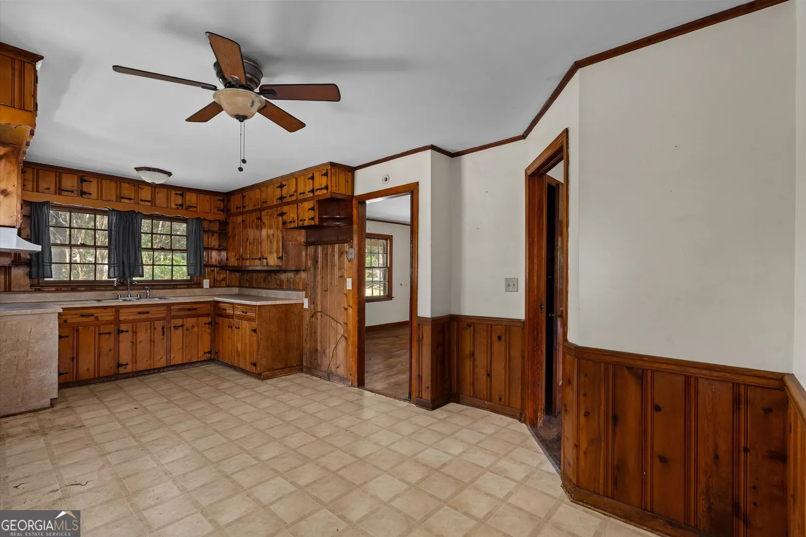 Kitchen looking toward the doorway, with a ceiling fan and tile floor