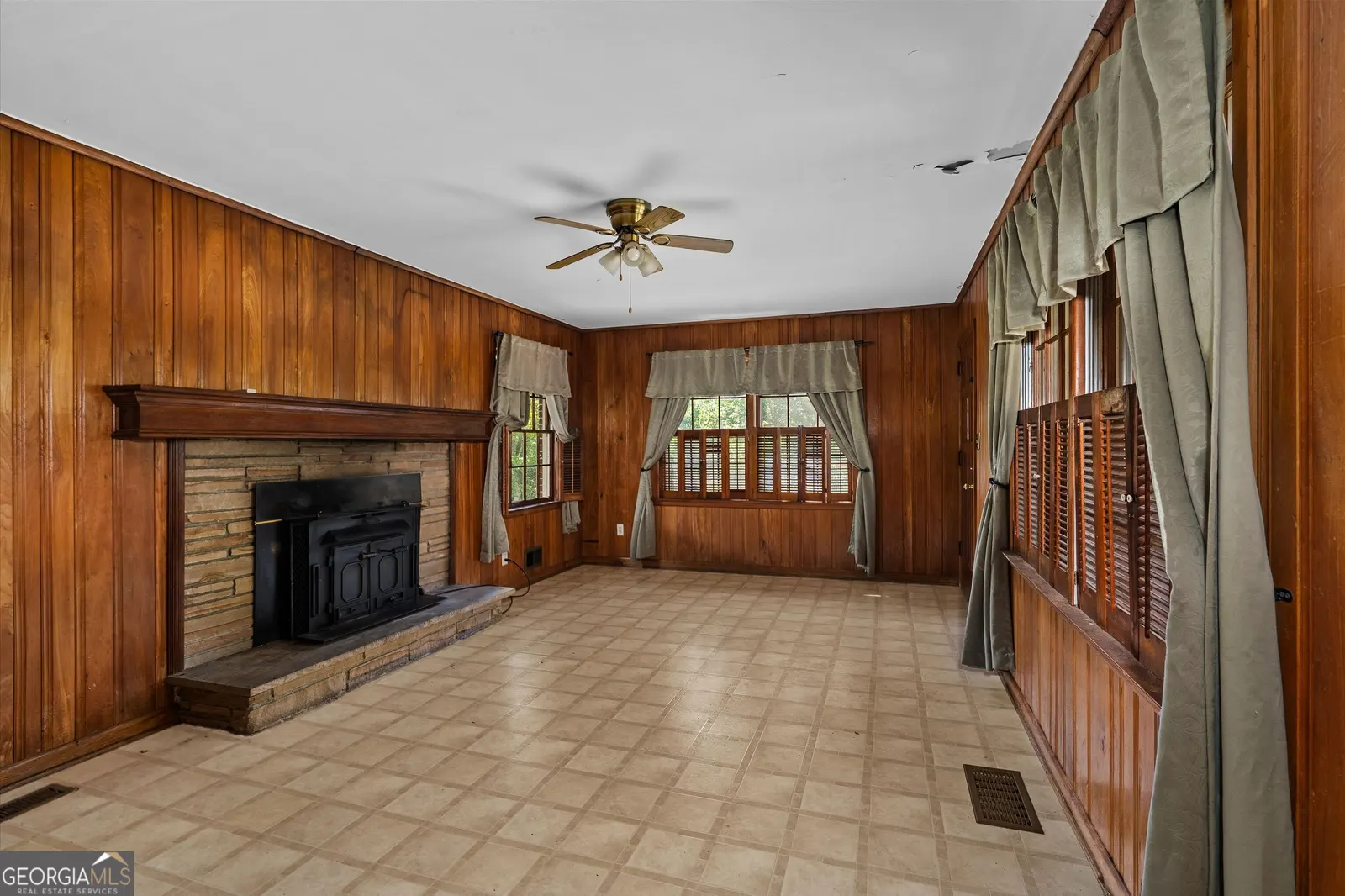 Panelled room with a brick fireplace and wood stove insert