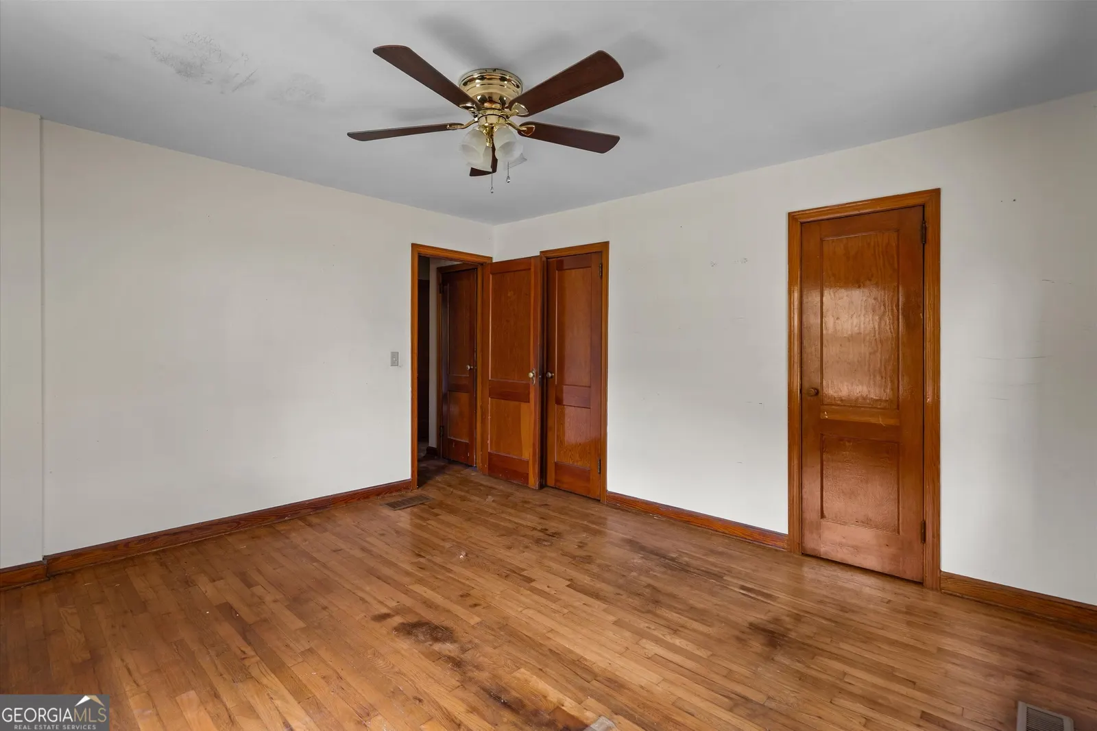 Bedroom with hardwood floors and two panelled wood doors