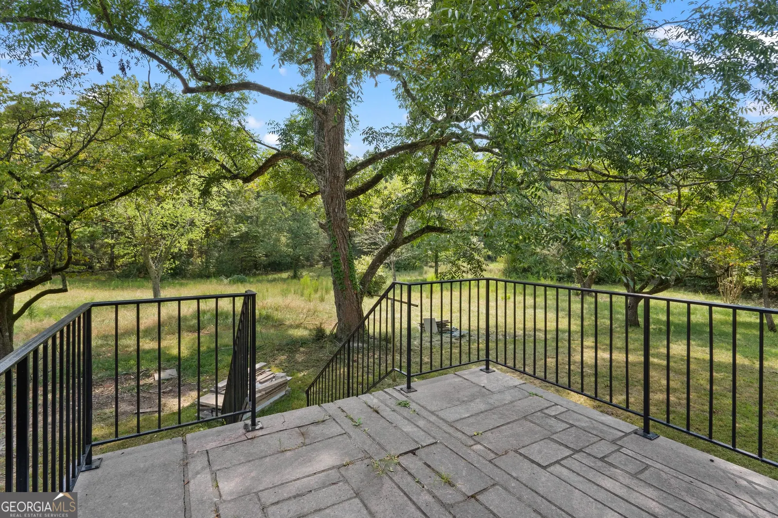 The view from the rear patio across the lawn to the tree line