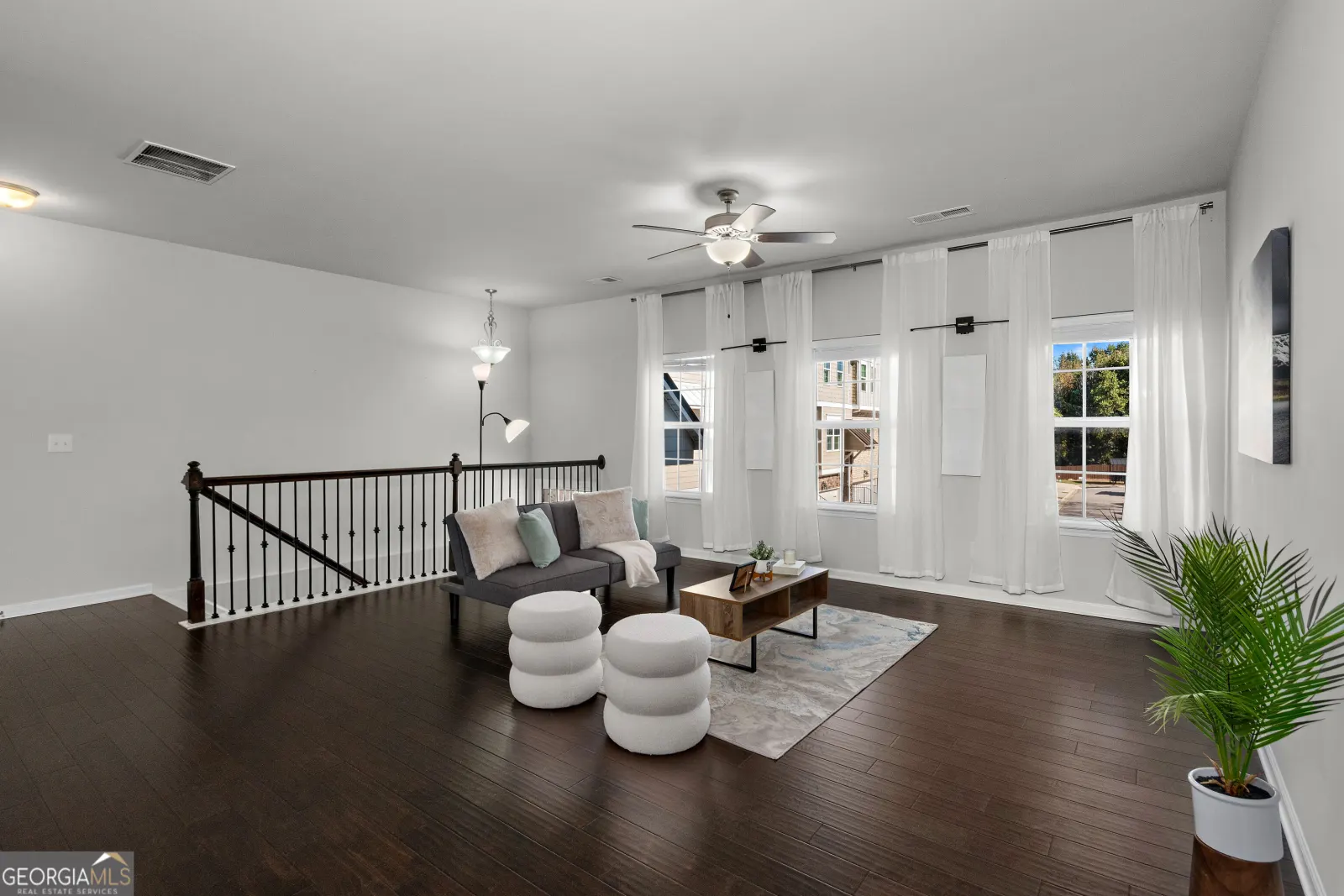 Living room from the front windows, with the stair railing and the dining area beyond
