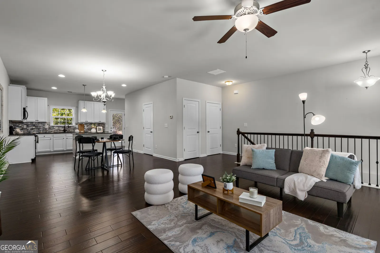 The open main level: living room in front, dining area in the middle and the white kitchen at the back