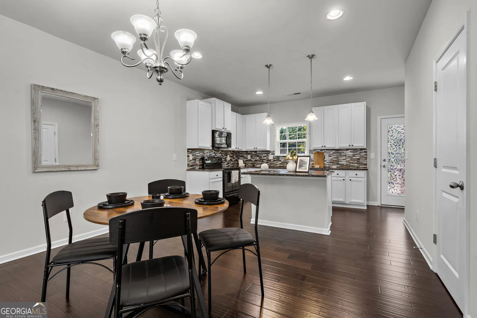 Dining area beside the kitchen island, with the back door to the deck