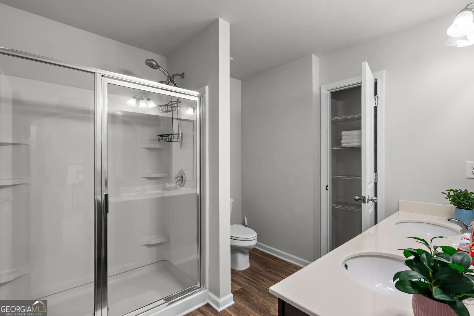Primary bathroom with a glass-door shower and a linen closet