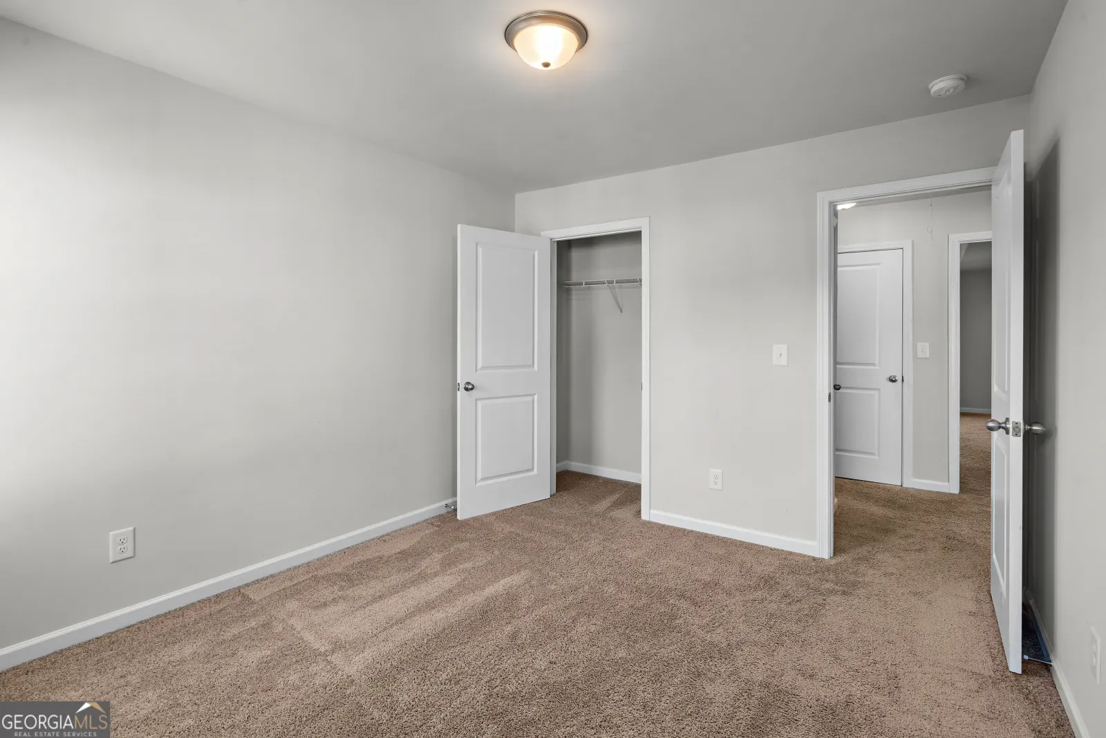 Upstairs bedroom with a reach-in closet, opening onto the hall