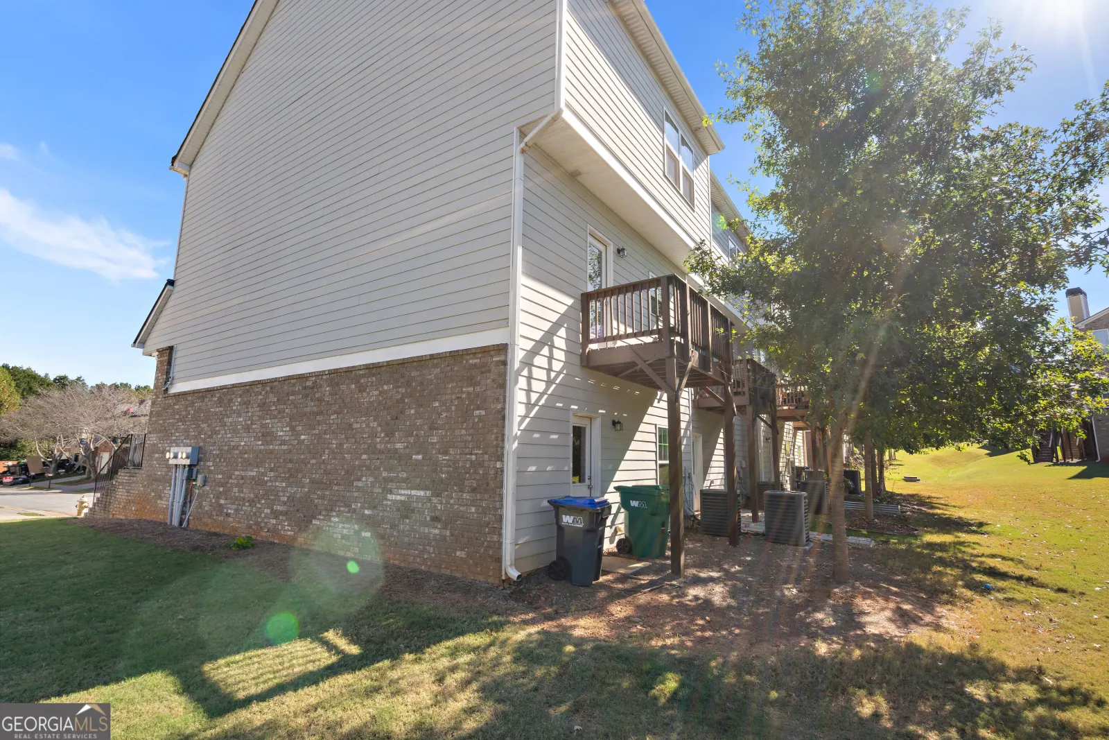 Side of the end unit, with its brick base, siding and the deck